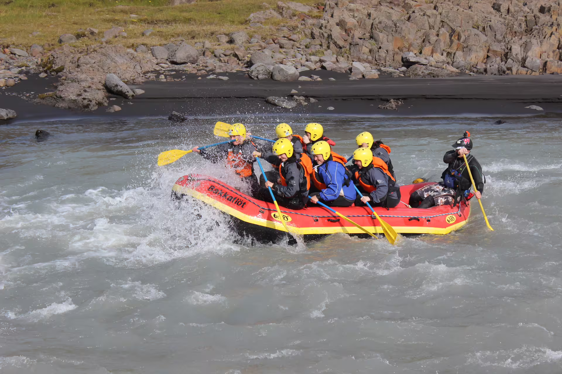 Family enjoying an exciting river rafting adventure, paddling through rapids with helmets and life jackets for safety.
