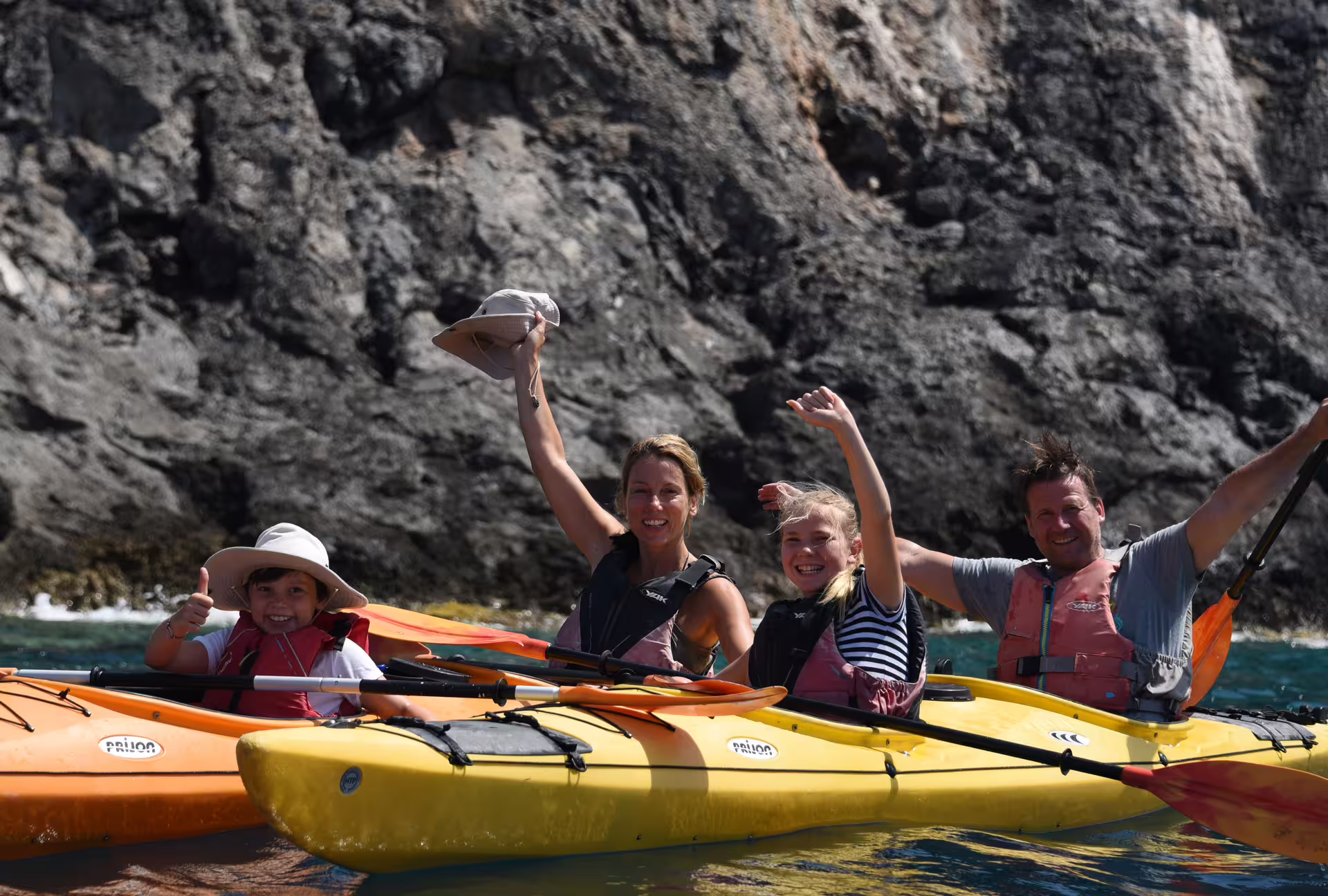 Family sea kayaking near Kardamyli and Stoupa, Mani Peninsula, paddling along rocky coast in Greece