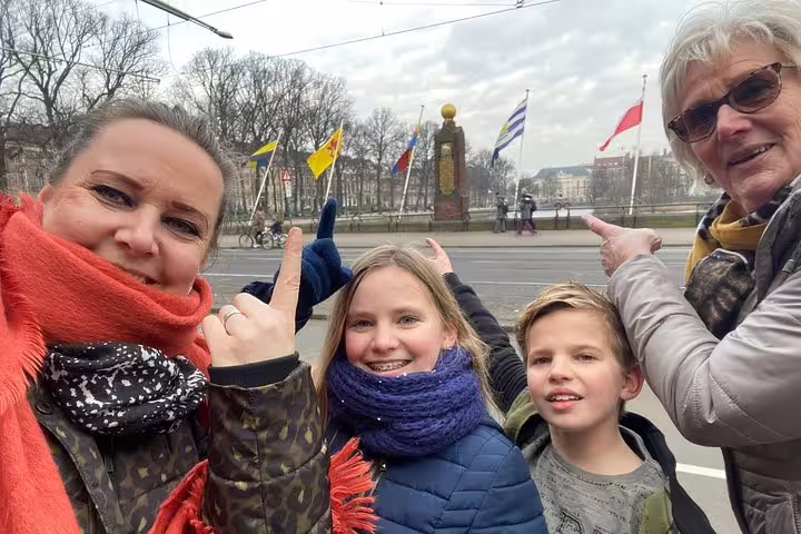 Family selfie by the flags at Hofvijver The Hague, playing a self-guided e-scavenger hunt city tour