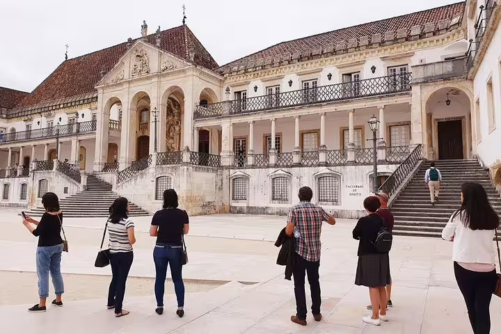 Tourists admiring the historic architecture of the University of Coimbra, a key stop on the Fátima & Coimbra tour.