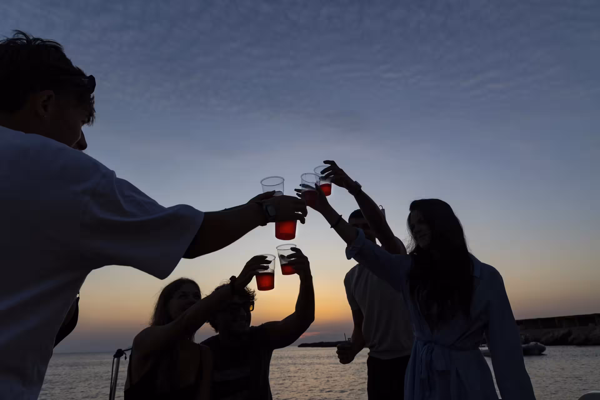 Guests toasting at sunset on Egadi Islands dinghy tour from Trapani to Favignana and Levanzo, lunch included