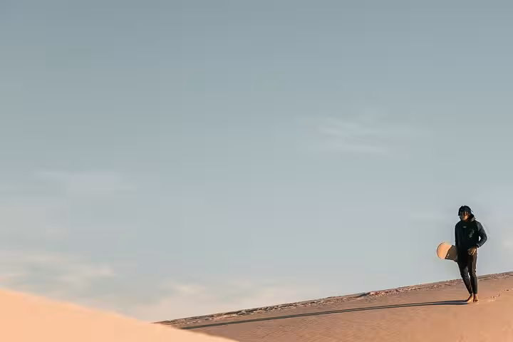 Traveler walking on Fayoum desert dunes at sunset near Wadi El Hitan, part of nature and heritage day tour