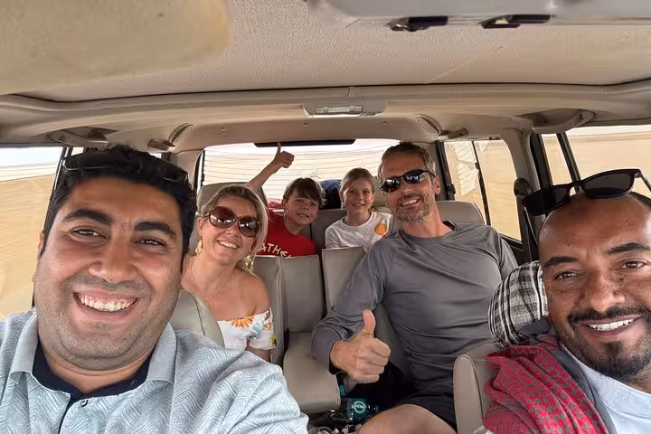 Happy family and guide inside 4x4 during Fayoum Oasis private full-day tour from Cairo across desert roads