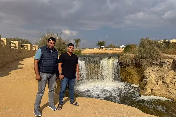Guests by a small waterfall in Fayoum Oasis on a private full-day tour from Cairo, Egypt desert escape