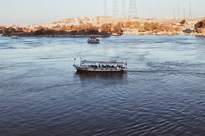 Boat crossing the Nile in Luxor with wide river view, ideal for felucca ride tour and sightseeing cruise