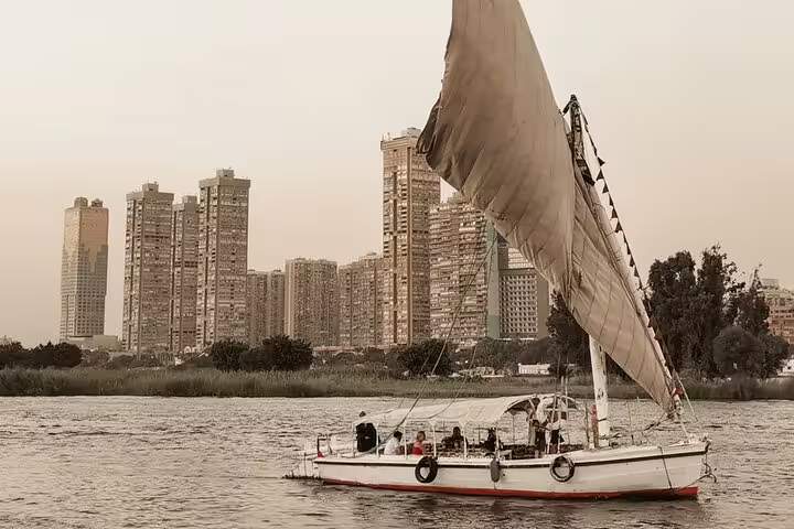 Traditional felucca sailboat on the Nile with Cairo skyline, part of Downtown Cairo half-day tour and dinner