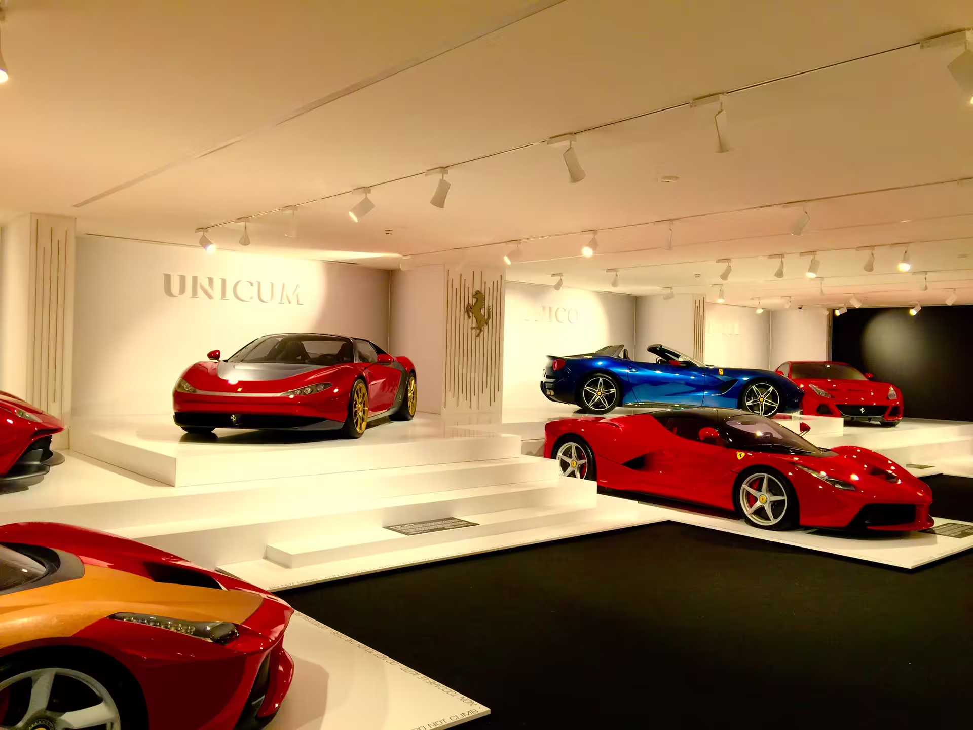 Stunning display of Ferrari models in vibrant colors at the Ferrari Museum in Maranello, showcasing automotive excellence.