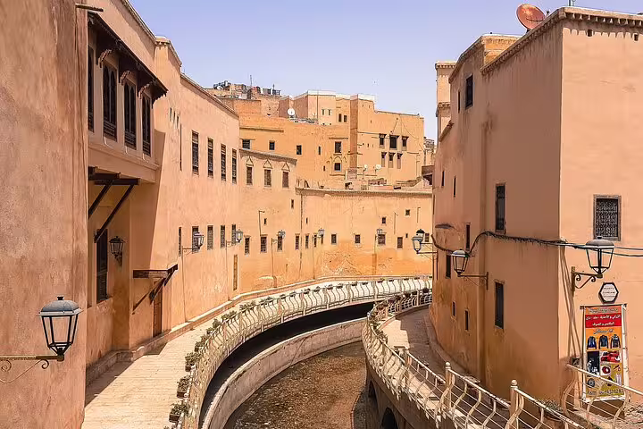 Scenic canal walkway between ochre buildings in Fes, Morocco, a highlight of Your Own Morocco self-guided tour