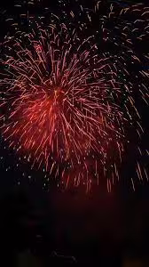 Fuochi d’artificio rossi nel cielo notturno sopra il mare di Ischia durante la tradizionale Festa di Sant’Anna in barca