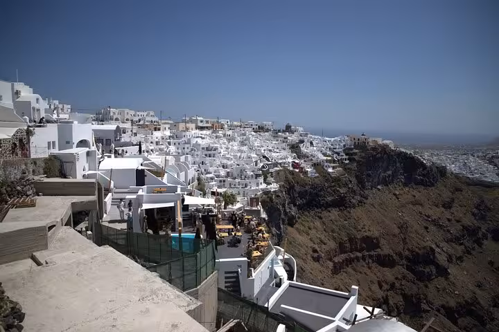 Panoramic Fira cliffside view of whitewashed houses and caldera on Santorini iconic highlights tour
