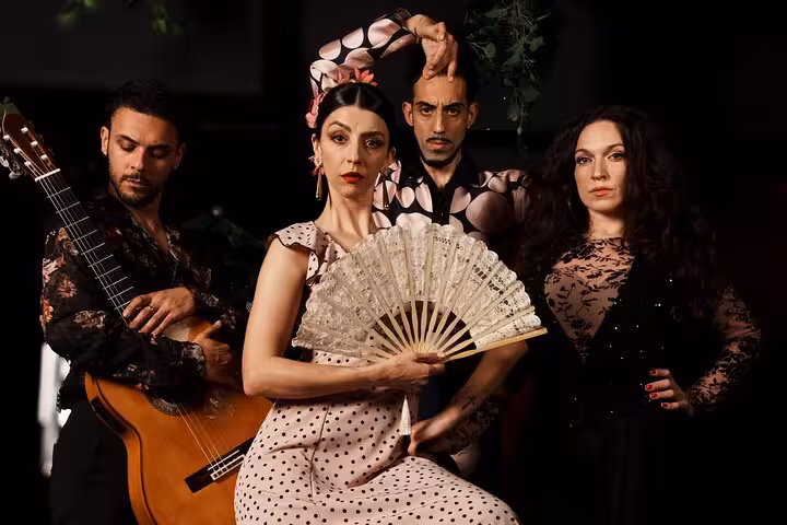 Flamenco performers with guitar and fan, showcasing traditional Spanish dance and music at a live show in Barcelona.