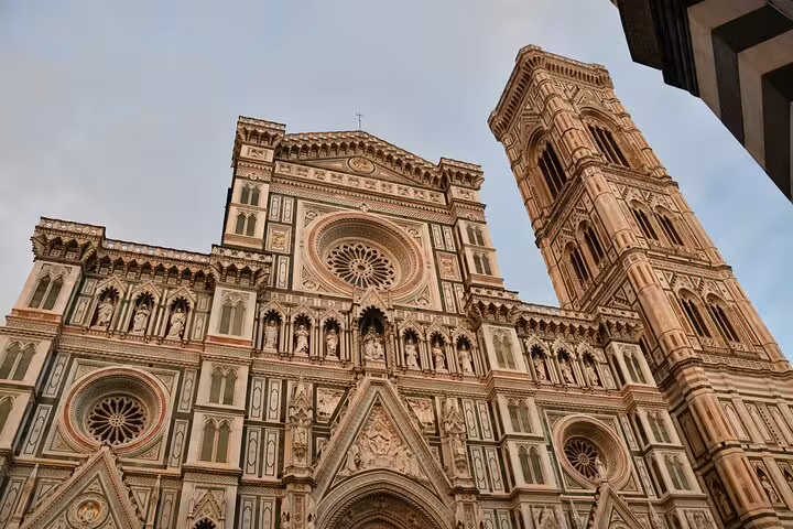 Close-up of Florence Cathedral facade and bell tower, highlighting intricate architectural details.