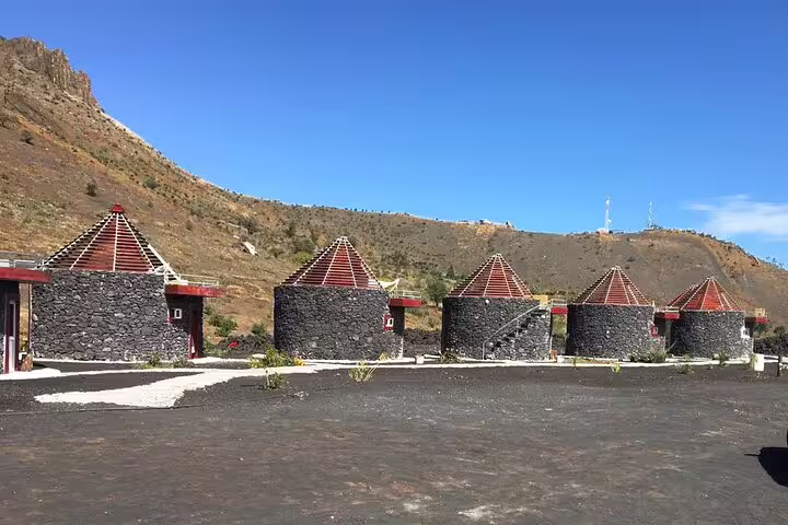 Unique round stone huts with conical roofs against Fogo Island's scenic backdrop, ideal for exploring cultural architecture.