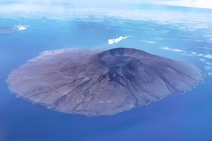 Aerial view of Fogo Island's volcanic landscape surrounded by azure ocean, perfect for a hiking and discovery adventure.