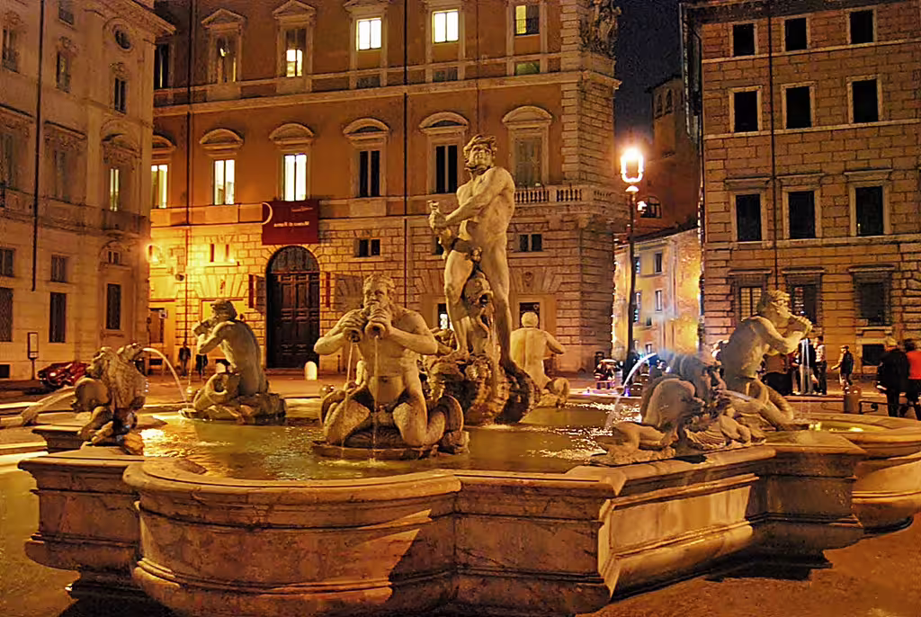 Night view of Rome’s Fontana del Nettuno in Piazza Navona, lit by warm streetlights on a Fountains and Squares walking tour