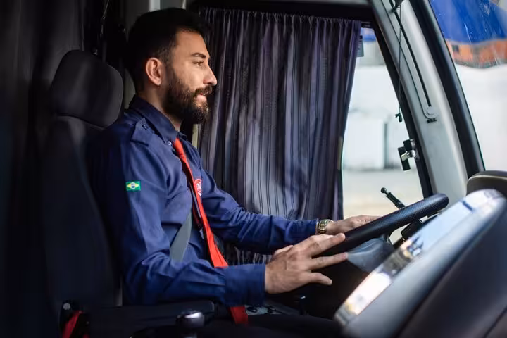 Professional driver inside air-conditioned coach for Fortaleza to Jericoacoara transfer, safe travel in Ceará