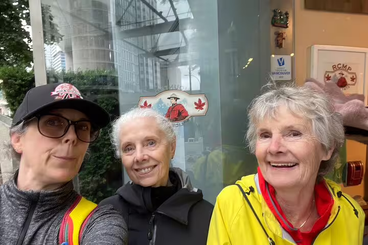 Friends smiling outside an RCMP-themed shop in Vancouver, completing clues on a Gastown scavenger hunt