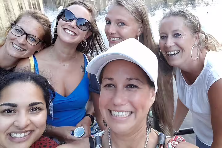 Friends smiling on a San Sebastián e-scavenger hunt, exploring the city at their own pace by the waterfront