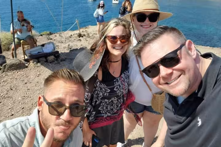 Friends enjoying a customized private Santorini coastal tour, group selfie by the Aegean Sea viewpoint