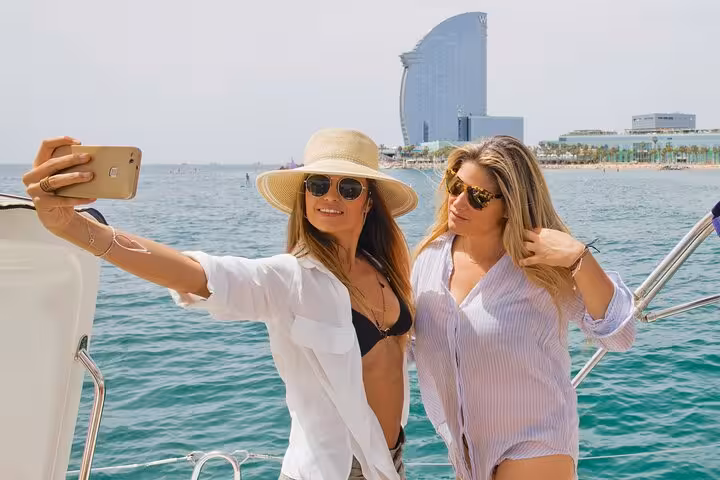 Friends taking a selfie on a private Barcelona sailing tour with open bar, snacks, and sea views