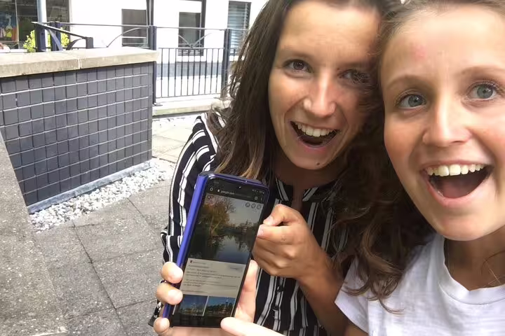 Friends use smartphone clues on a self-guided e-scavenger hunt in Bonn, Germany, exploring at own pace