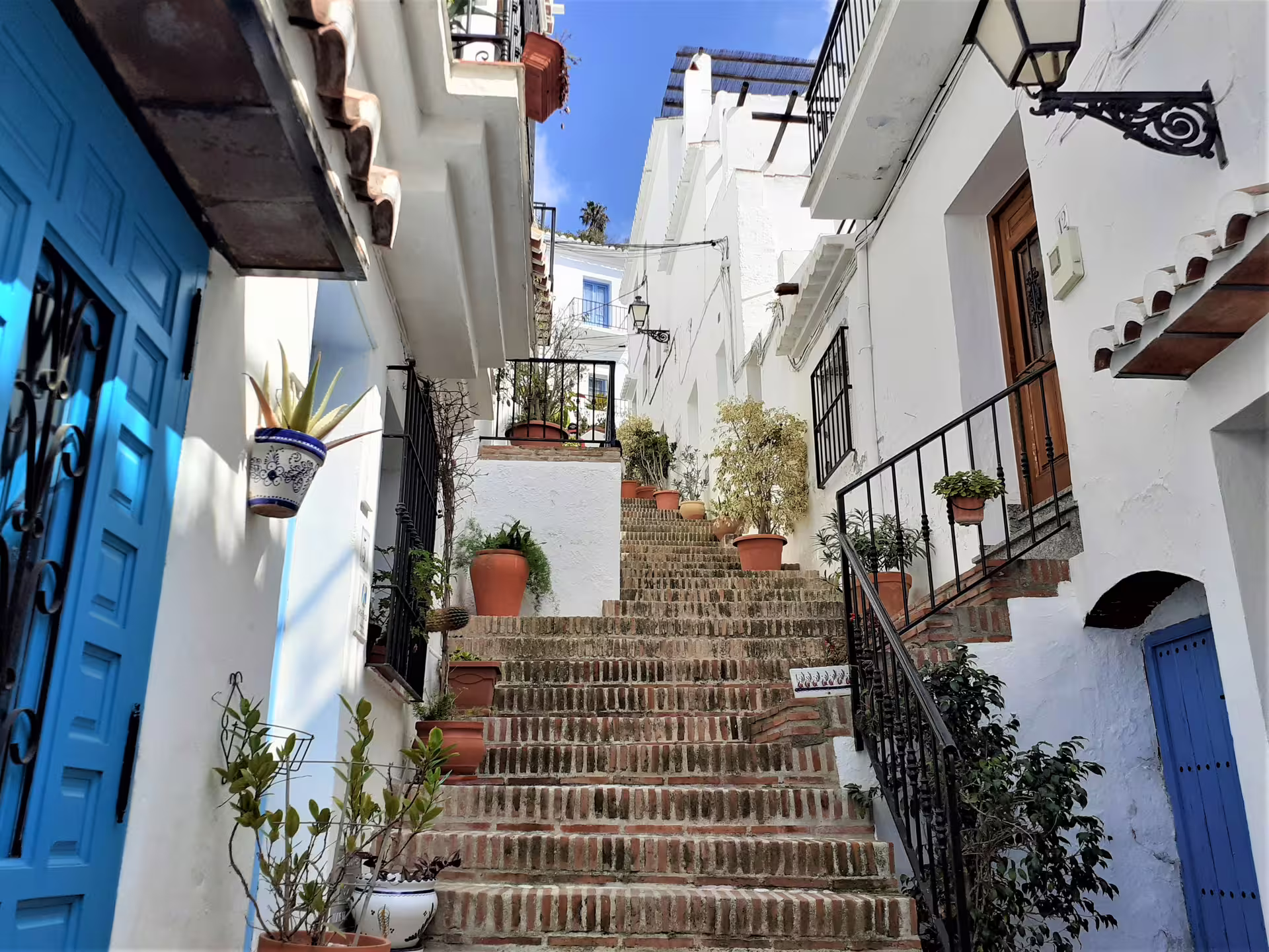 Brick stairway in Frigiliana old town with whitewashed houses and blue doors on private tour from Marbella