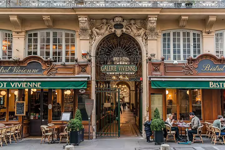 Charming entrance to Galerie Vivienne in Paris with elegant architecture and cozy bistro, a hidden gem for explorers.