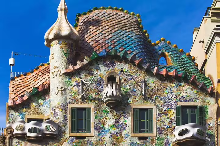 Vibrant facade of Gaudi's Casa Batlló in Barcelona, showcasing colorful mosaics and unique architecture on a sunny day.