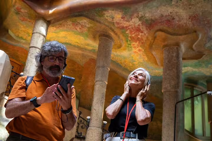 Senior travelers enjoy an audio-guided morning tour inside Gaudí’s La Pedrera, admiring the colorful modernist ceiling in Barcelona