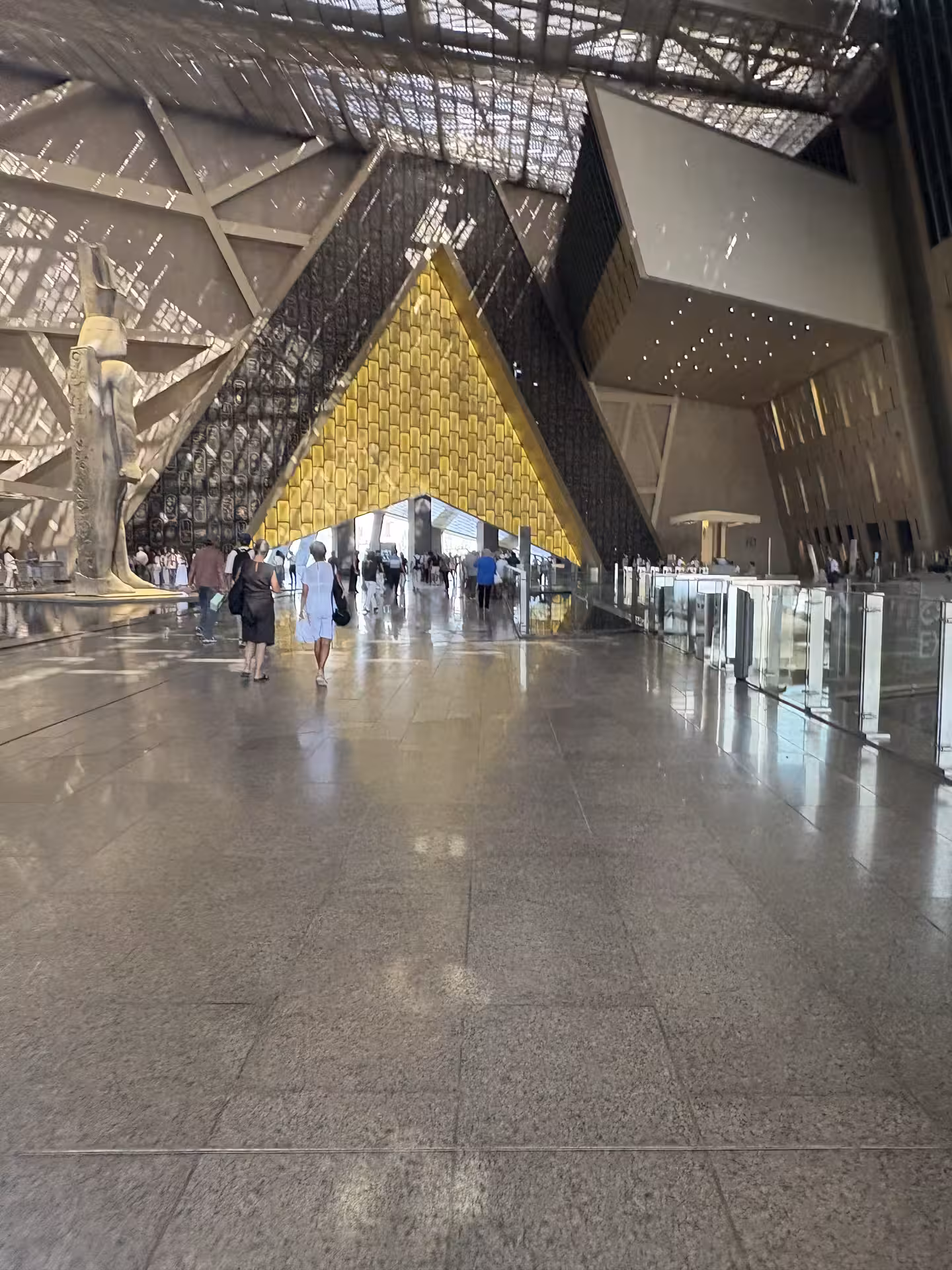 Spacious GEM lobby with golden pyramid facade and statues, part of all-inclusive Giza pyramids tour