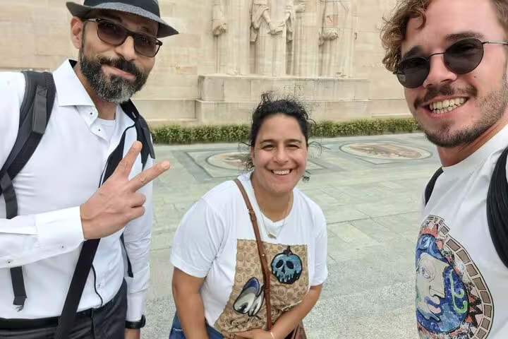 Smiling travelers selfie at Geneva Reformation Wall during a city highlights scavenger hunt walking activity
