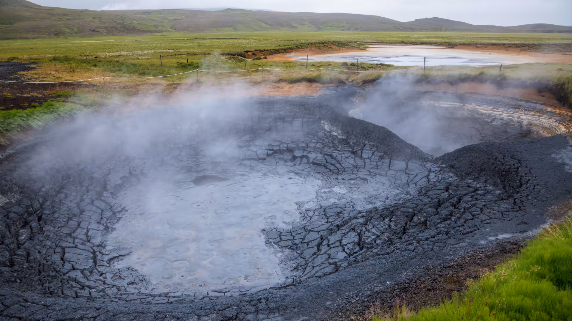 Steaming mud pot and cracked clay at Krýsuvík geothermal field, Iceland, on geothermal sprint adventure