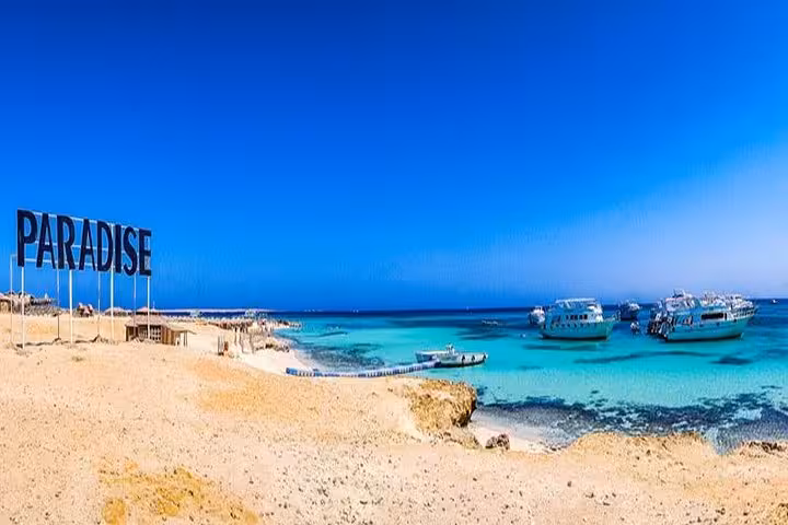 Paradise Beach on Giftun Island with snorkeling boats anchored in clear Red Sea water on full-day trip