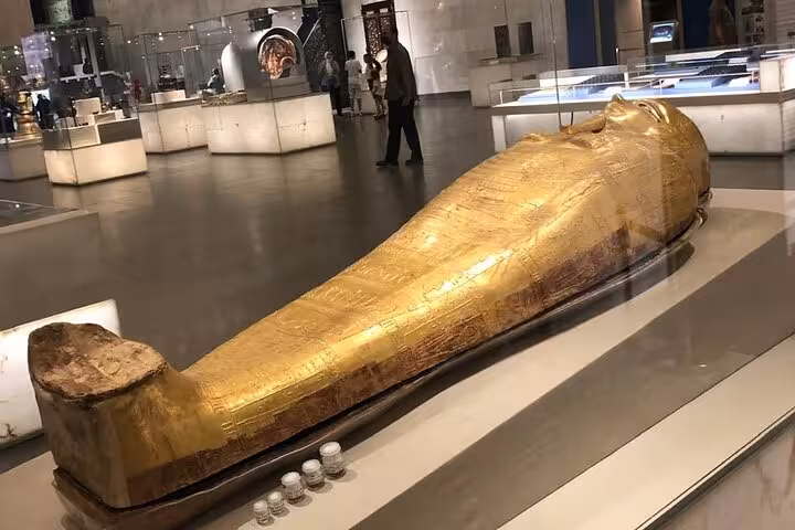 Gilded ancient Egyptian sarcophagus display at the Grand Egyptian Museum in Cairo on a private guided tour