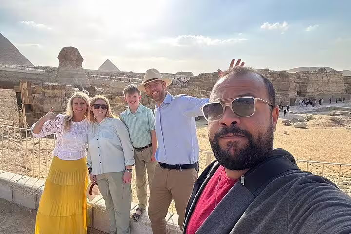 Group selfie with tour guide at Giza Plateau near the Sphinx and pyramids during a half-day Cairo tour