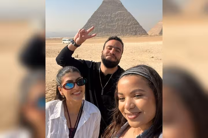 Friends selfie at Giza Pyramid viewpoint on half-day pyramids tour, sandy plateau and pyramid backdrop