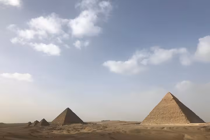 Wide view of the Giza Pyramids under a blue sky, iconic Cairo sightseeing stop on Egypt day tour