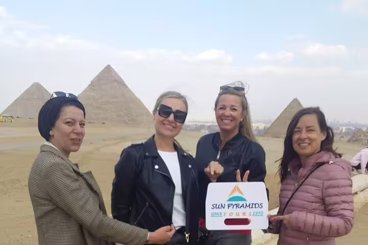 Travelers pose at the Giza Pyramids viewpoint on a private guided Cairo tour with Egyptian Museum and bazaar