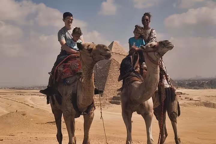 Family camel ride near Giza Pyramids on private tour with quad biking, lunch included, and entrance tickets
