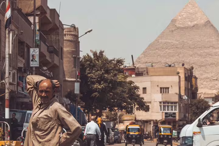Cairo street scene with the Great Pyramid of Giza in background, gateway to Giza Pyramids camel tour day trip