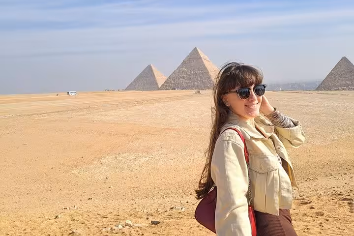 Traveler posing at the Giza Pyramids desert viewpoint on an all-inclusive full-day Cairo tour with guide