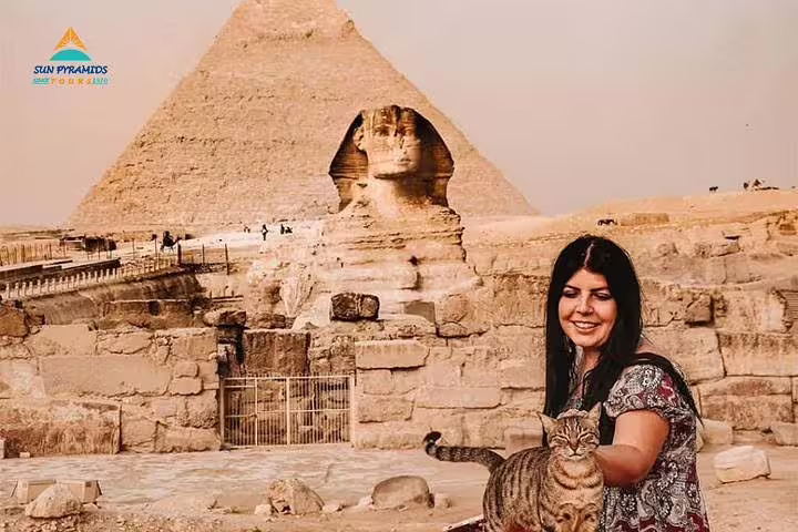 Tourist with cat beside the Great Sphinx and Pyramid of Khafre on a Giza half-day carriage tour