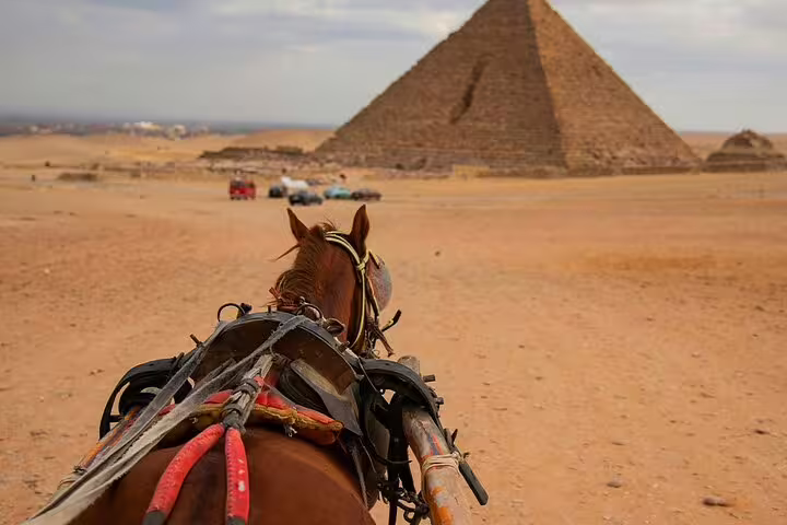 Couple riding a horse carriage with Giza pyramids view on a half-day Cairo tour across the desert