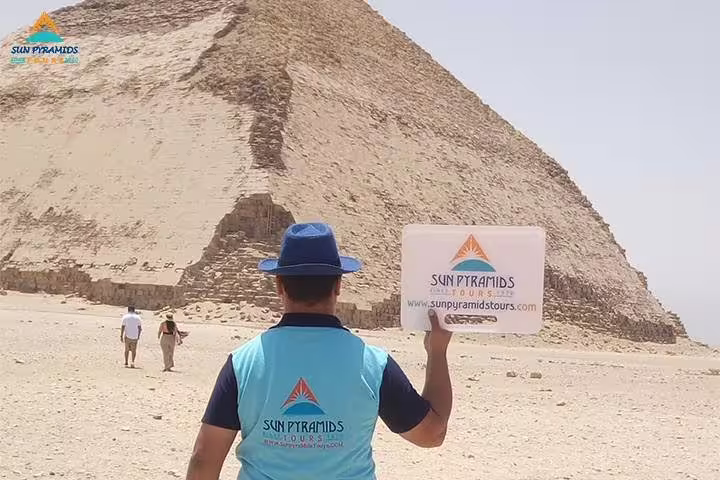Tour guide at Giza Pyramids holding sign, Cairo day tour to Memphis, Dahshur, Saqqara, El-Moez and Cairo Tower