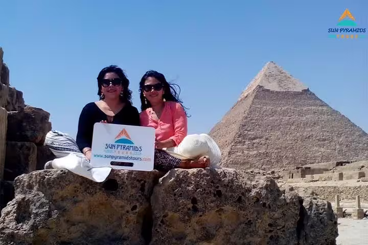 Travelers posing at Giza Pyramids with tour sign, Cairo itinerary to Memphis, Dahshur, Saqqara pyramids, El-Moez and Cairo Tower