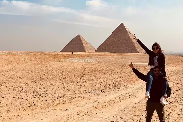 Travelers posing by the Giza Pyramids on a shore excursion from El Sokhna Port with Nile lunch cruise