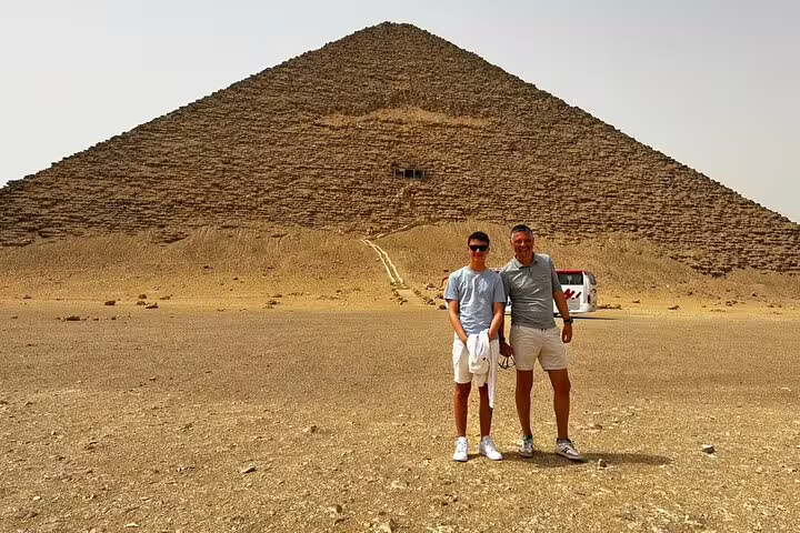 Guests posing at the Great Pyramid of Giza on a private tour from Alexandria Port with Egyptologist guide