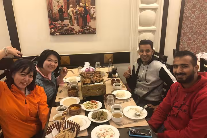 Guests enjoying Egyptian lunch included on a private Giza Pyramids tour with quad biking, camel ride and entrance tickets