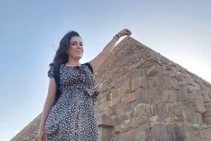 Traveler posing beside the Great Pyramid of Giza on a private tour with quad biking, camels, tickets and lunch