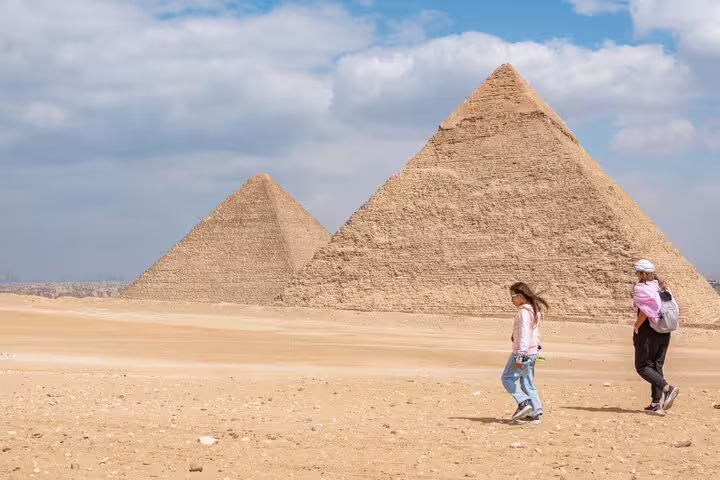 Travelers walking by the Giza Pyramids on a private shore excursion from El Sokhna Port to Cairo highlights